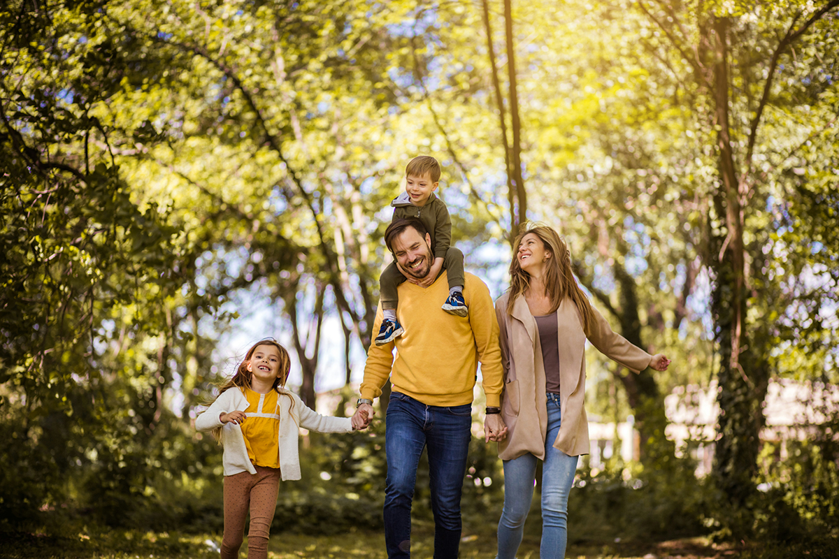 A family walking together through a sunlit park