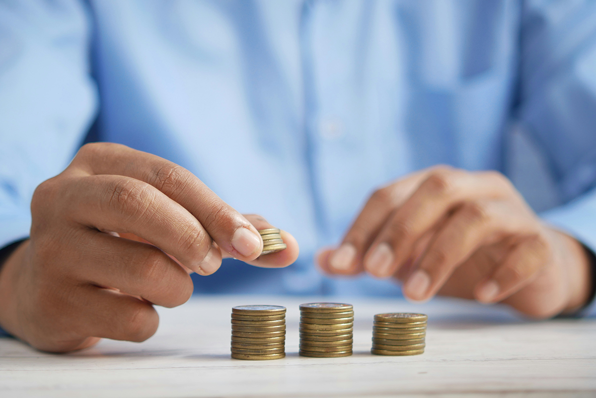 Hands stacking coins in growing columns