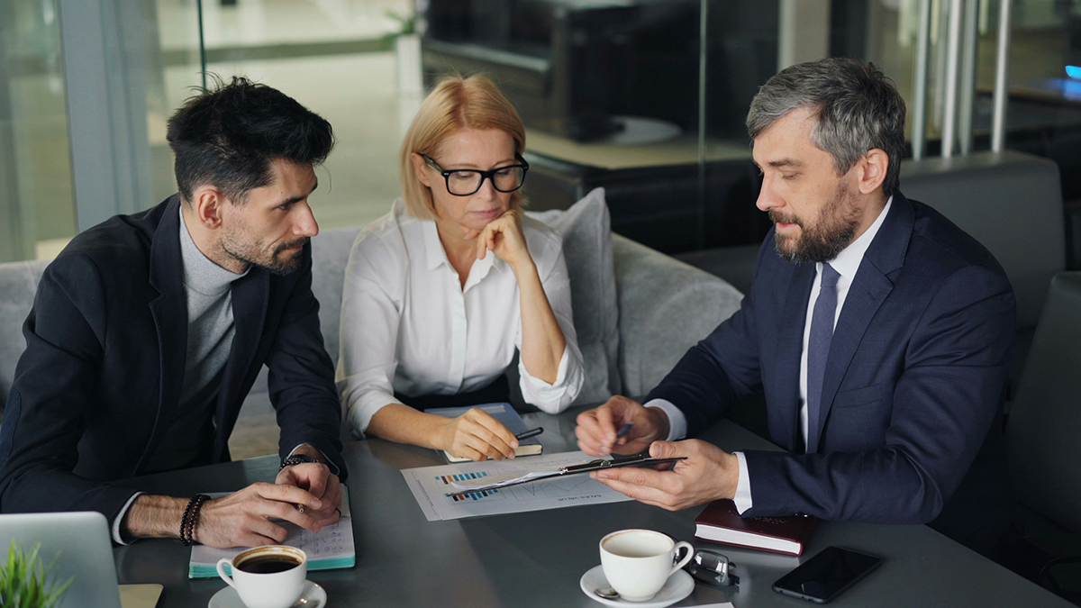 An adviser reviewing documents with two clients