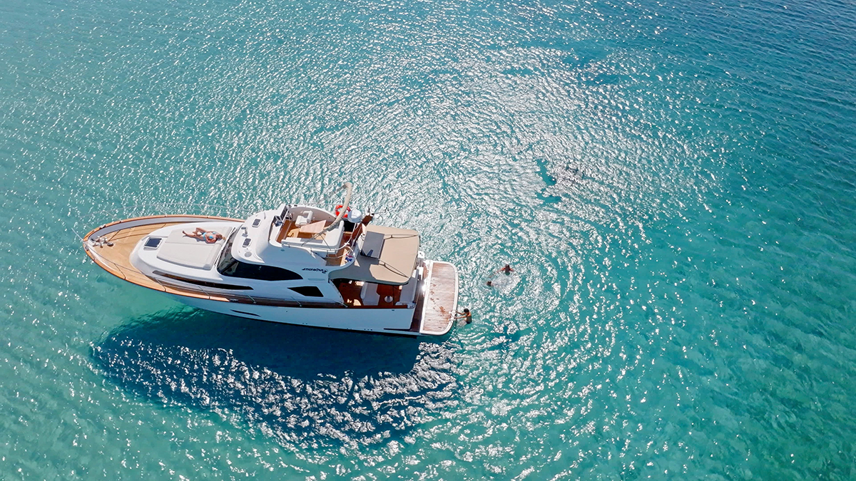 An aerial view of a luxury yacht on turquoise water