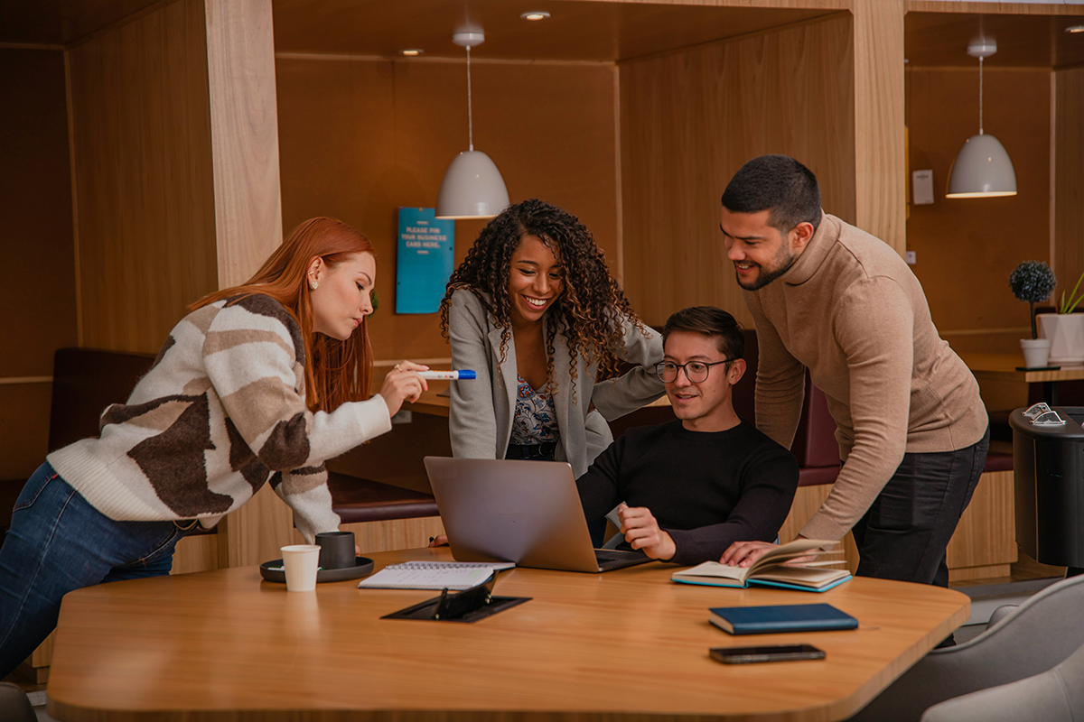 A team collaborating around a laptop